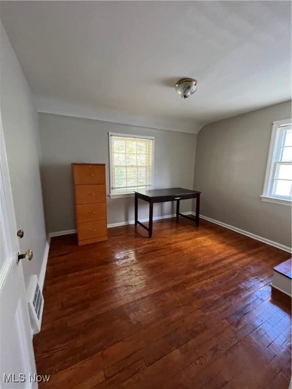 empty room with baseboards, dark wood finished floors, and visible vents