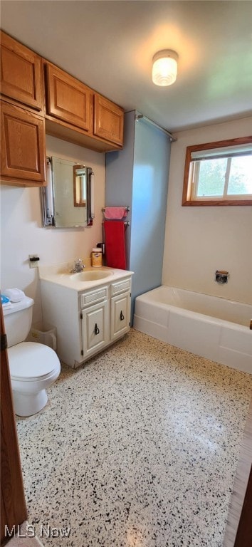bathroom with toilet, vanity, and a tub to relax in