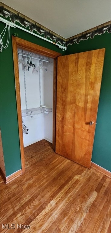 unfurnished bedroom featuring baseboards and wood finished floors