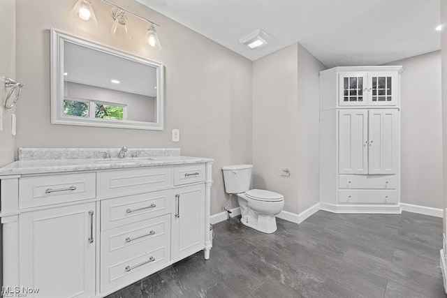 13109 Edison St NE, Alliance, OH 44601 - bathroom with baseboards, vanity, toilet, and wood finished floors