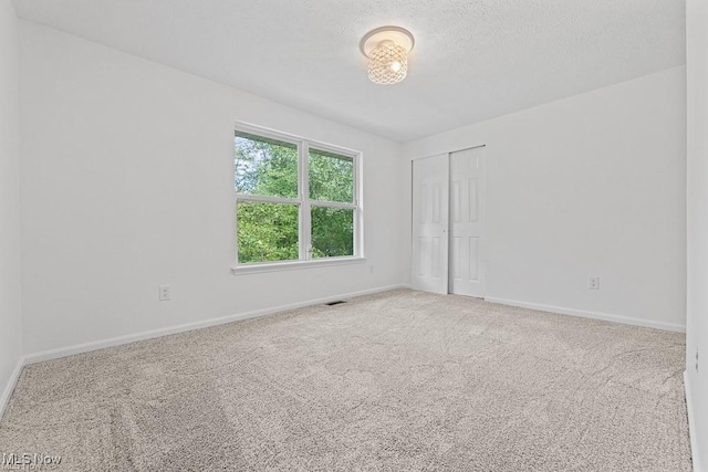 13109 Edison St NE, Alliance, OH 44601 - carpeted empty room with a textured ceiling, baseboards, and visible vents