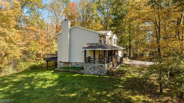 13109 Edison St NE, Alliance, OH 44601 - back of house featuring a yard, a chimney, a view of trees, and covered porch