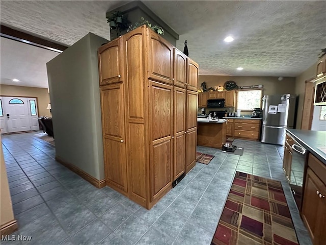 13978 Sprucevale Rd, East Liverpool, OH 43920 - kitchen with freestanding refrigerator, a textured ceiling, dark tile patterned floors, black microwave, and brown cabinets