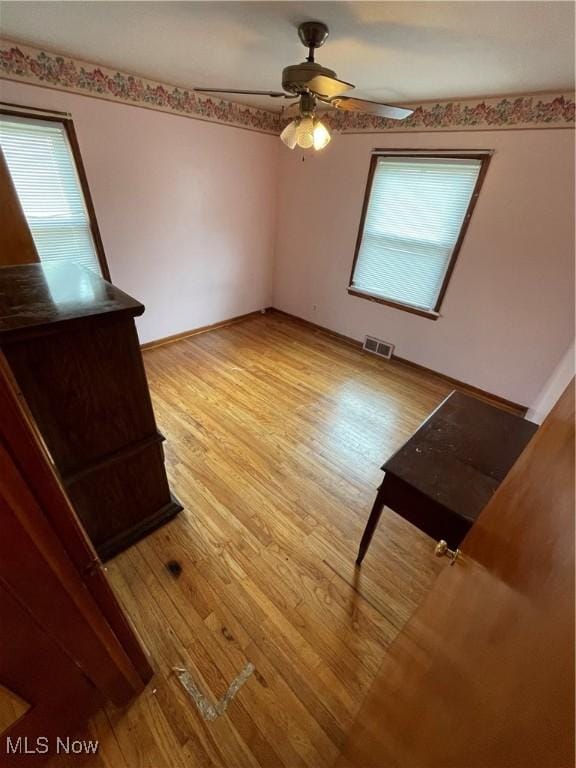 interior space featuring ceiling fan, visible vents, and light wood-style floors