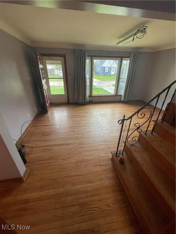 interior space featuring baseboards, stairway, and light wood-style flooring