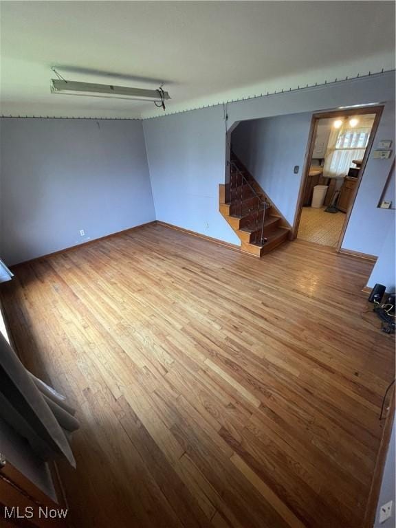 unfurnished living room with stairway and wood finished floors