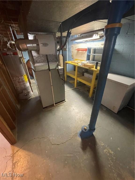 unfinished basement with a workshop area, heating unit, and gas water heater