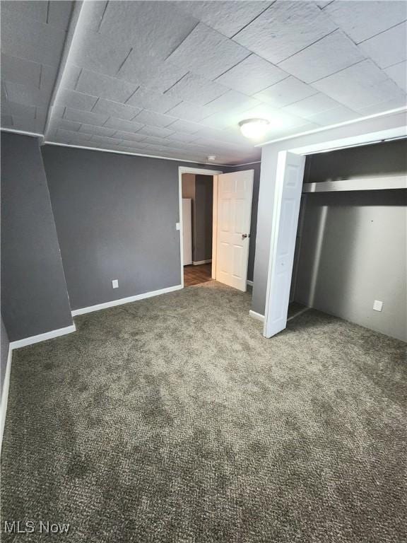 unfurnished bedroom featuring baseboards, a closet, and carpet