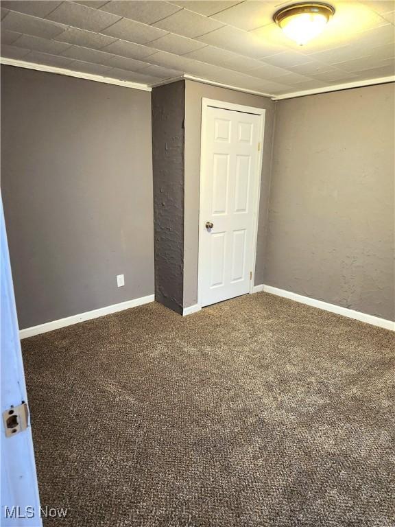 unfurnished bedroom featuring a closet, baseboards, and carpet floors