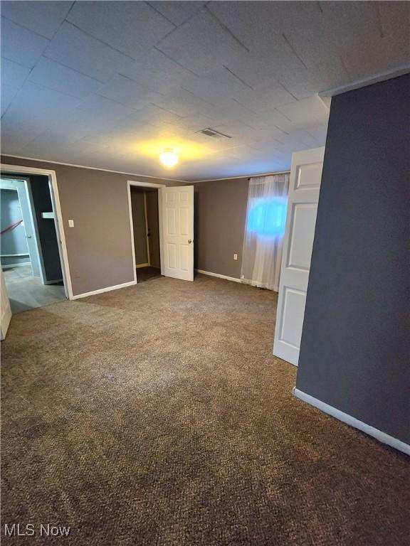 carpeted empty room with baseboards