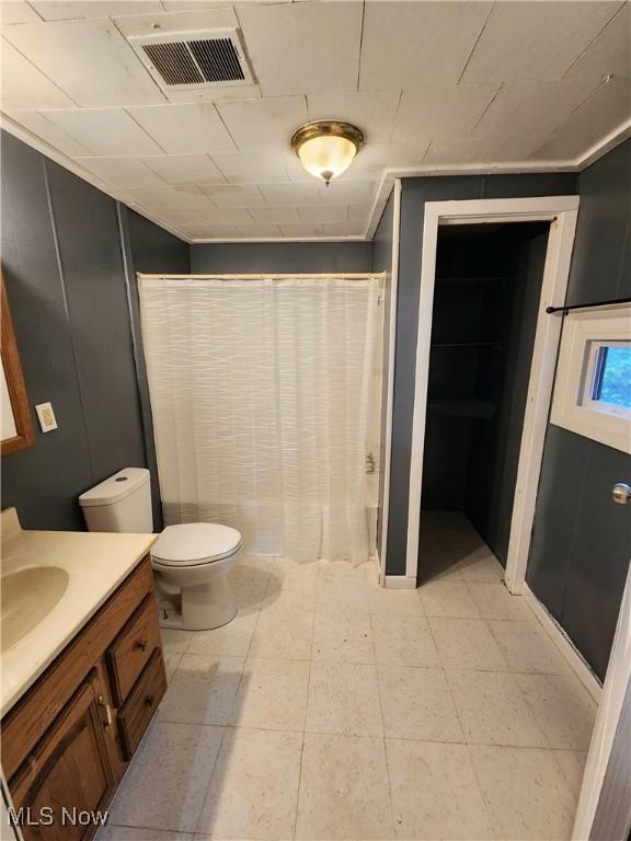 bathroom featuring curtained shower, visible vents, toilet, and vanity