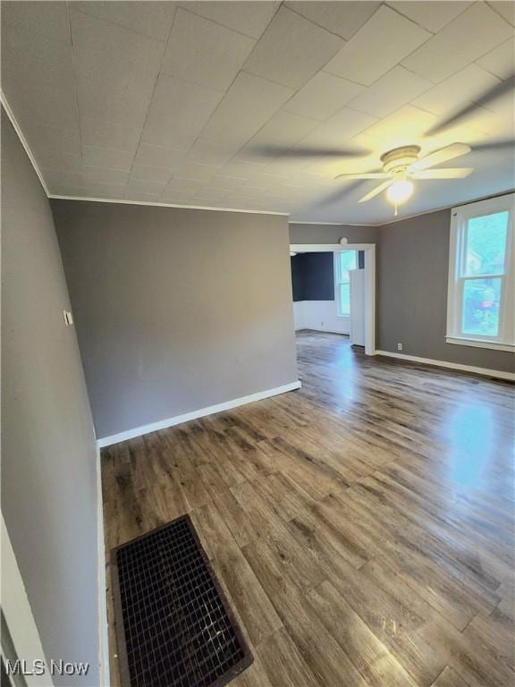 unfurnished room featuring wood finished floors, baseboards, and ceiling fan
