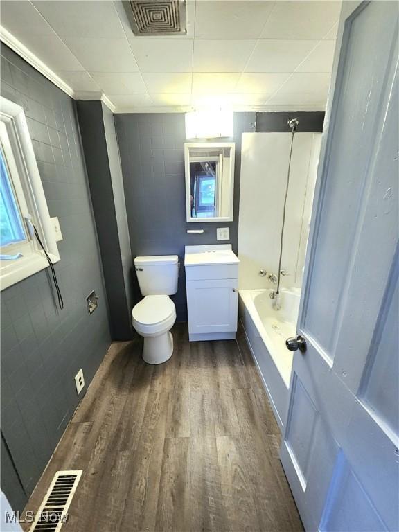 bathroom with toilet, vanity, visible vents, and wood finished floors