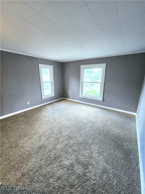 carpeted empty room featuring baseboards