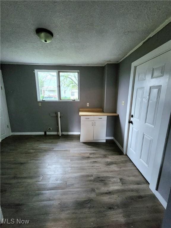 washroom with dark wood-style flooring, a textured ceiling, and baseboards