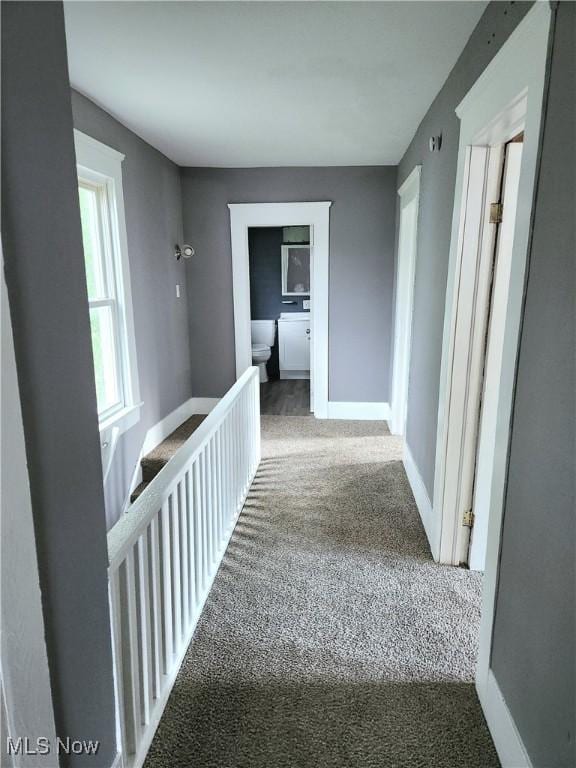 corridor with carpet and baseboards