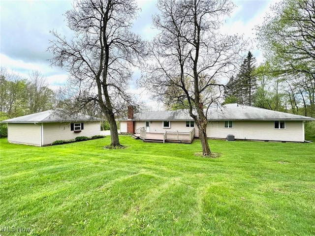 rear view of house with a yard and a wooden deck