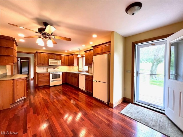 kitchen with a sink, white appliances, brown cabinets, open shelves, and dark wood-style floors