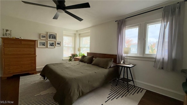 bedroom featuring wood finished floors, baseboards, and a ceiling fan