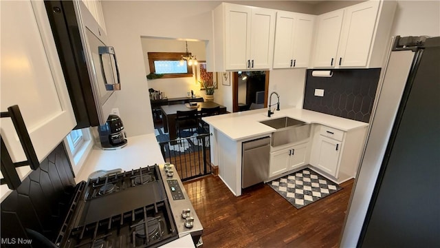 kitchen with dark wood finished floors, appliances with stainless steel finishes, white cabinets, and a sink