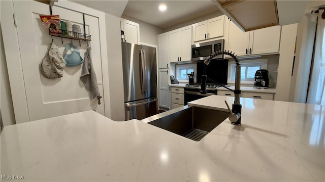 kitchen featuring light countertops, white cabinets, and appliances with stainless steel finishes