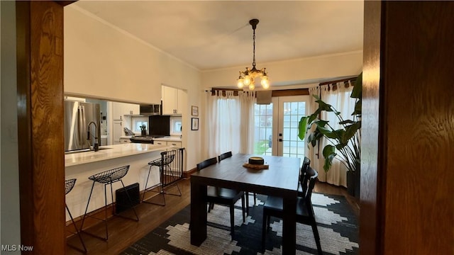 dining area featuring ornamental molding, an inviting chandelier, dark wood-style floors, and french doors