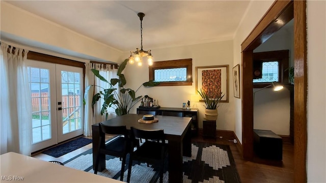 dining area featuring baseboards, french doors, a notable chandelier, and wood finished floors