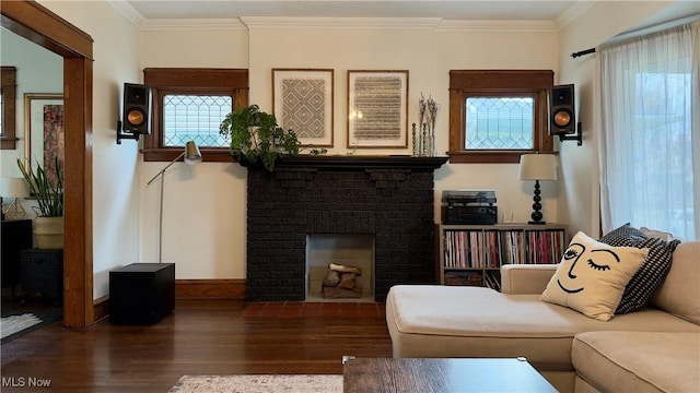 living area with a fireplace, crown molding, baseboards, and wood finished floors