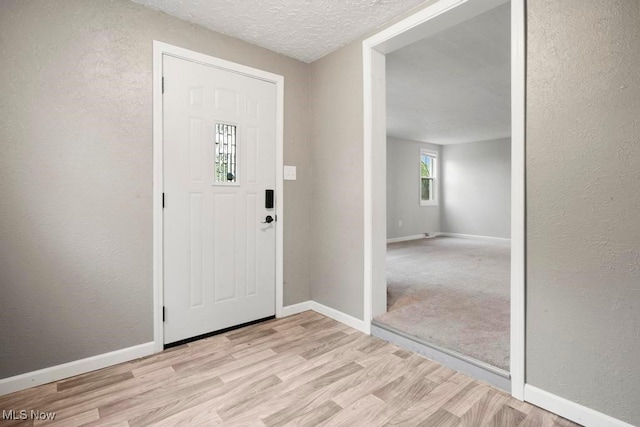 5331 Ridgewood St, Lorain, OH 44055 - entryway featuring a textured ceiling, a textured wall, baseboards, and light wood-type flooring