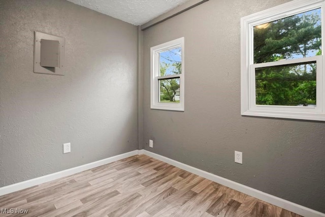 5331 Ridgewood St, Lorain, OH 44055 - unfurnished room with baseboards, light wood-style flooring, electric panel, and a textured wall