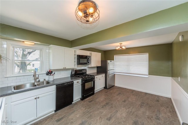 3019 Clague Rd, North Olmsted, OH 44070 - kitchen featuring an inviting chandelier, a sink, decorative backsplash, black appliances, and dark countertops