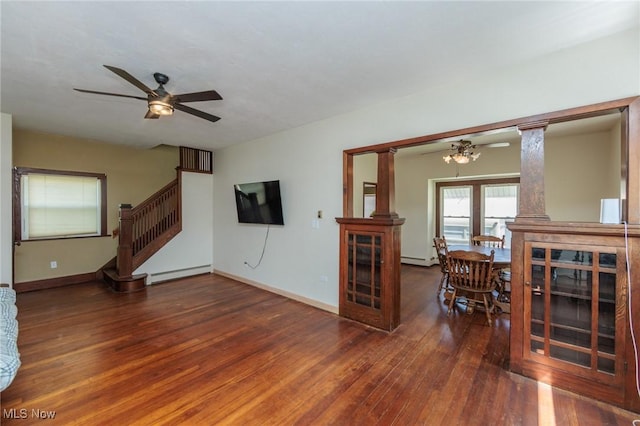 3019 Clague Rd, North Olmsted, OH 44070 - unfurnished living room featuring ornate columns, hardwood / wood-style floors, baseboard heating, ceiling fan, and stairs