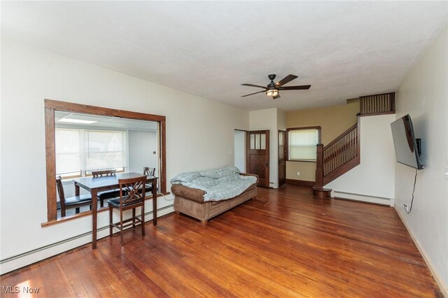 3019 Clague Rd, North Olmsted, OH 44070 - living area with a baseboard heating unit, stairway, a ceiling fan, and wood finished floors