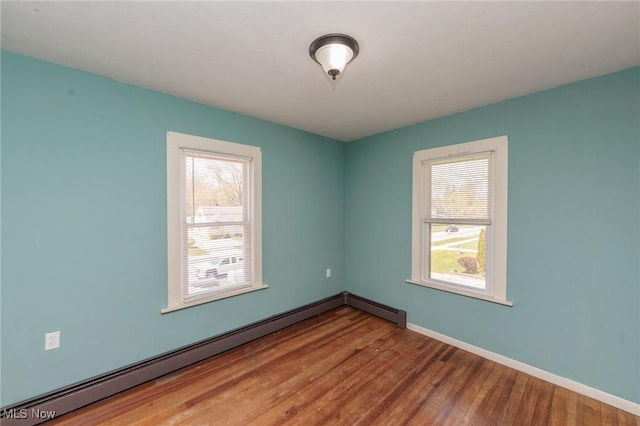 3019 Clague Rd, North Olmsted, OH 44070 - unfurnished room featuring baseboards, wood finished floors, and baseboard heating