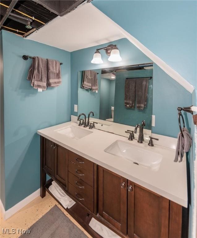 3019 Clague Rd, North Olmsted, OH 44070 - bathroom with baseboards, double vanity, and a sink