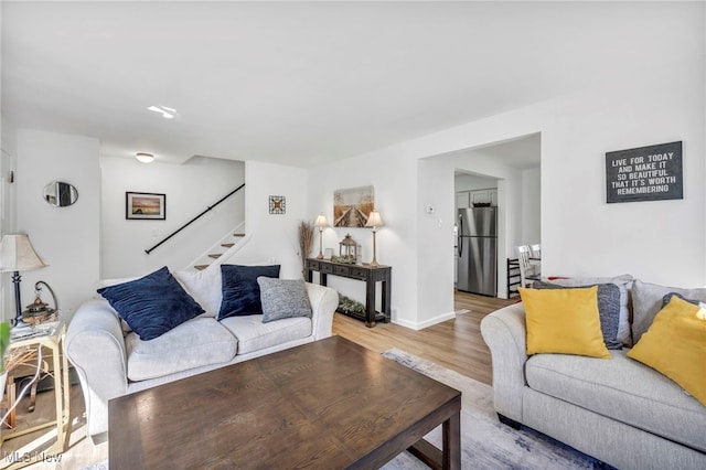 living area with stairs and wood finished floors