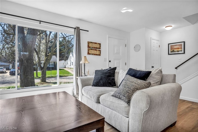 living room with baseboards, stairway, and wood finished floors