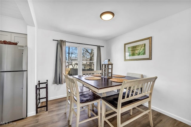 dining space featuring baseboards and wood finished floors