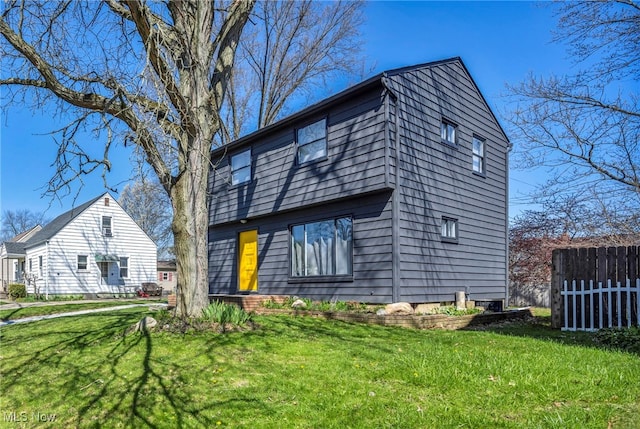 back of house featuring a yard and fence