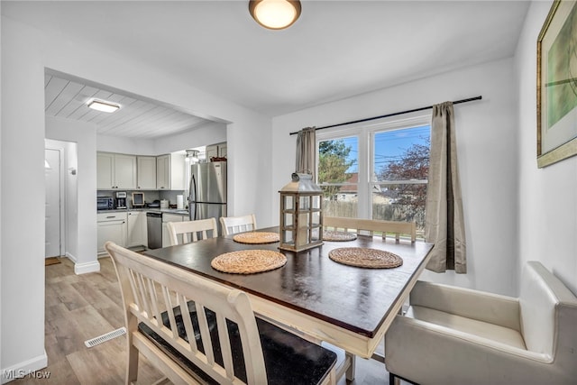 dining room with baseboards and light wood-style floors