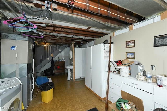 unfinished below grade area with washer / clothes dryer and a sink