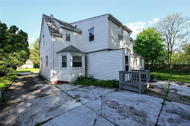 rear view of house with a patio and fence