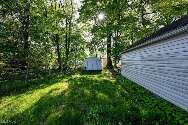 view of yard with an outbuilding, fence, and a storage unit
