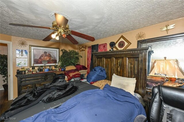 bedroom with a textured ceiling and a ceiling fan