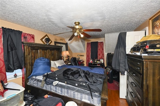 bedroom featuring a textured ceiling, wood finished floors, and ceiling fan