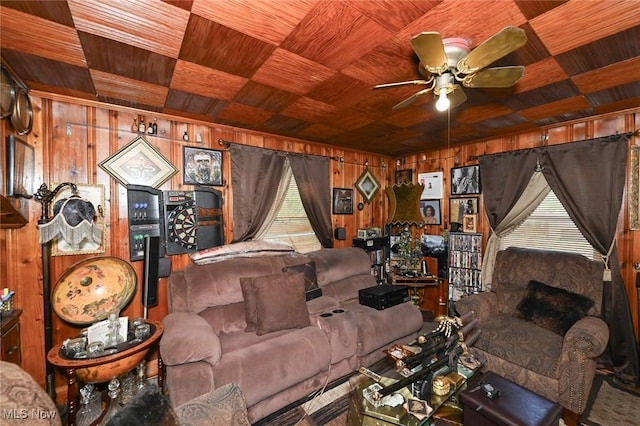 living area featuring wooden walls, ceiling fan, and wooden ceiling