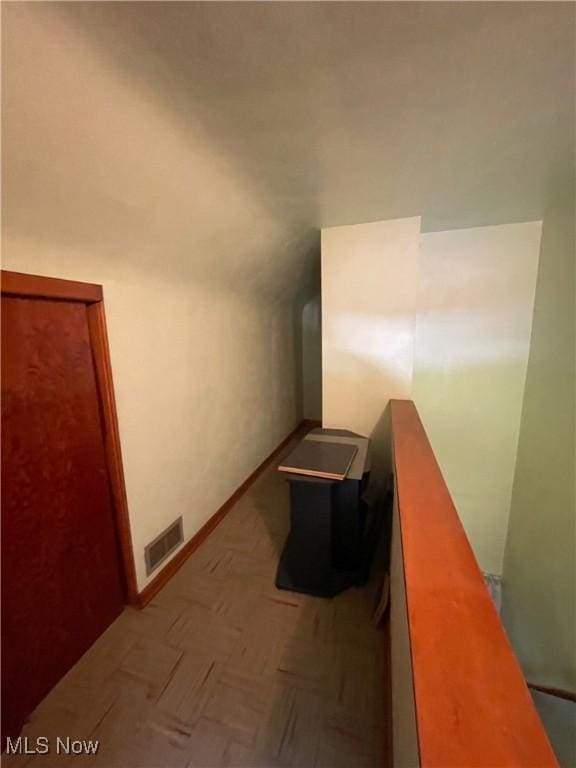 hall featuring baseboards, an upstairs landing, and visible vents