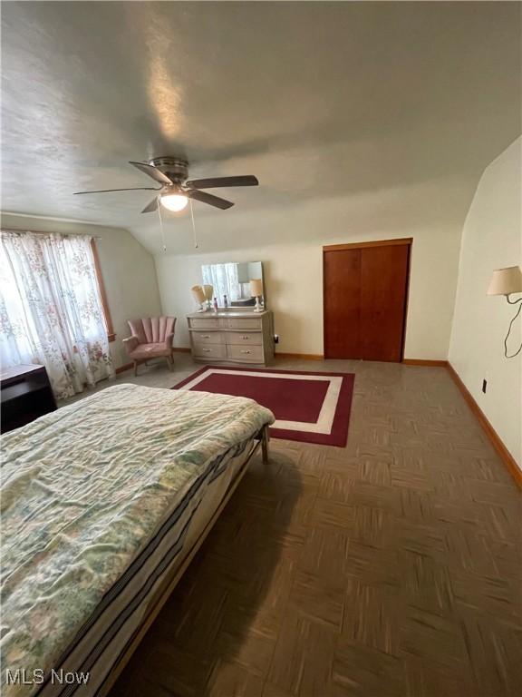 bedroom featuring baseboards, lofted ceiling, and ceiling fan