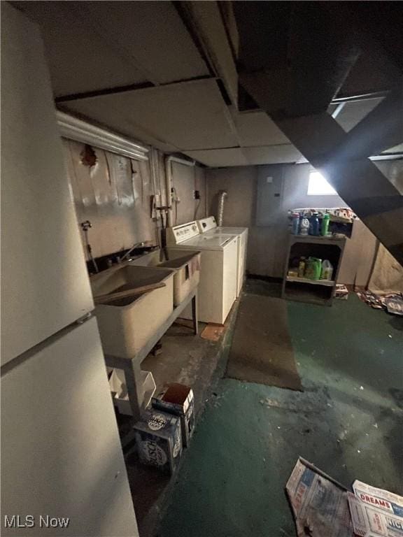 unfinished basement with separate washer and dryer and a sink
