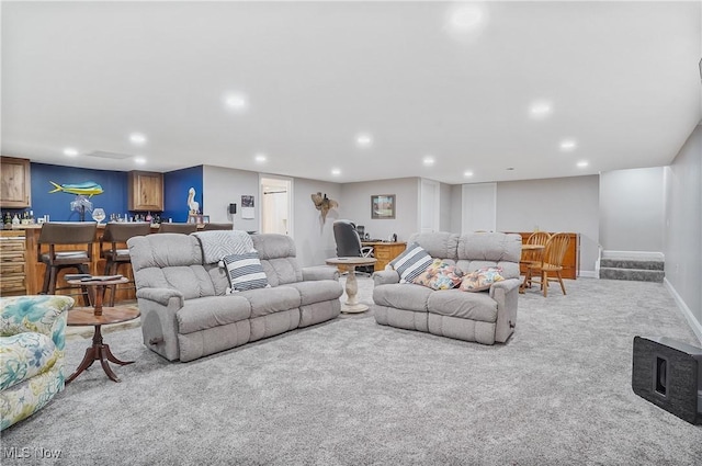 carpeted living area with baseboards, bar area, and recessed lighting